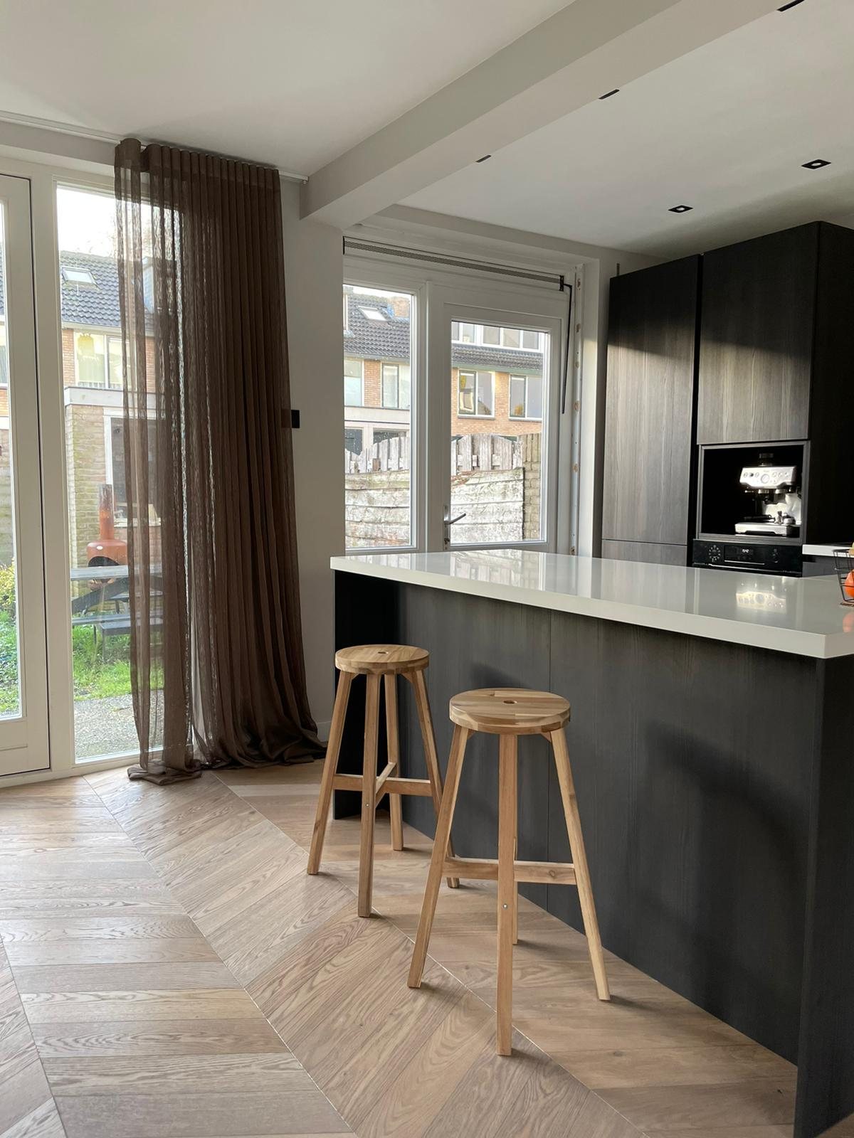 Keuken met kookeiland en visgraatvloer in Abcoude