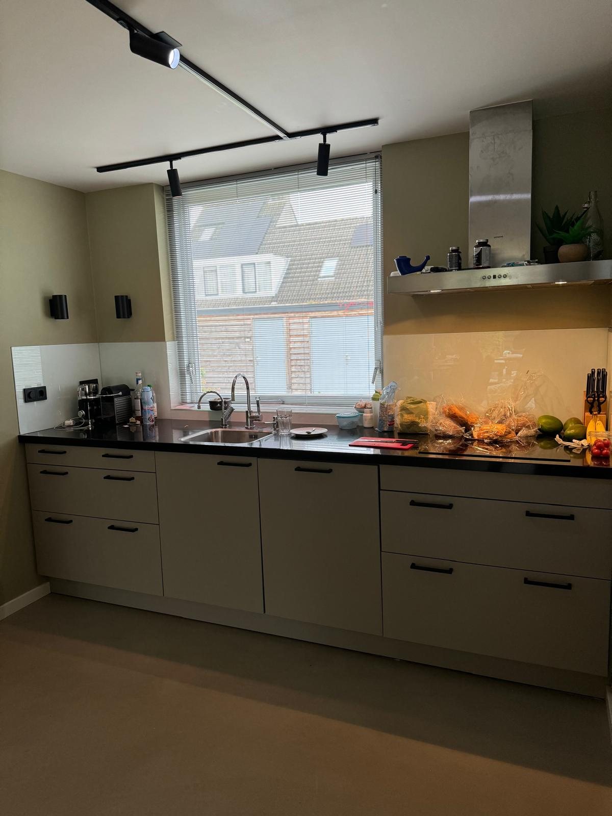 Nieuwe keuken met lang werkblad onder het raam
