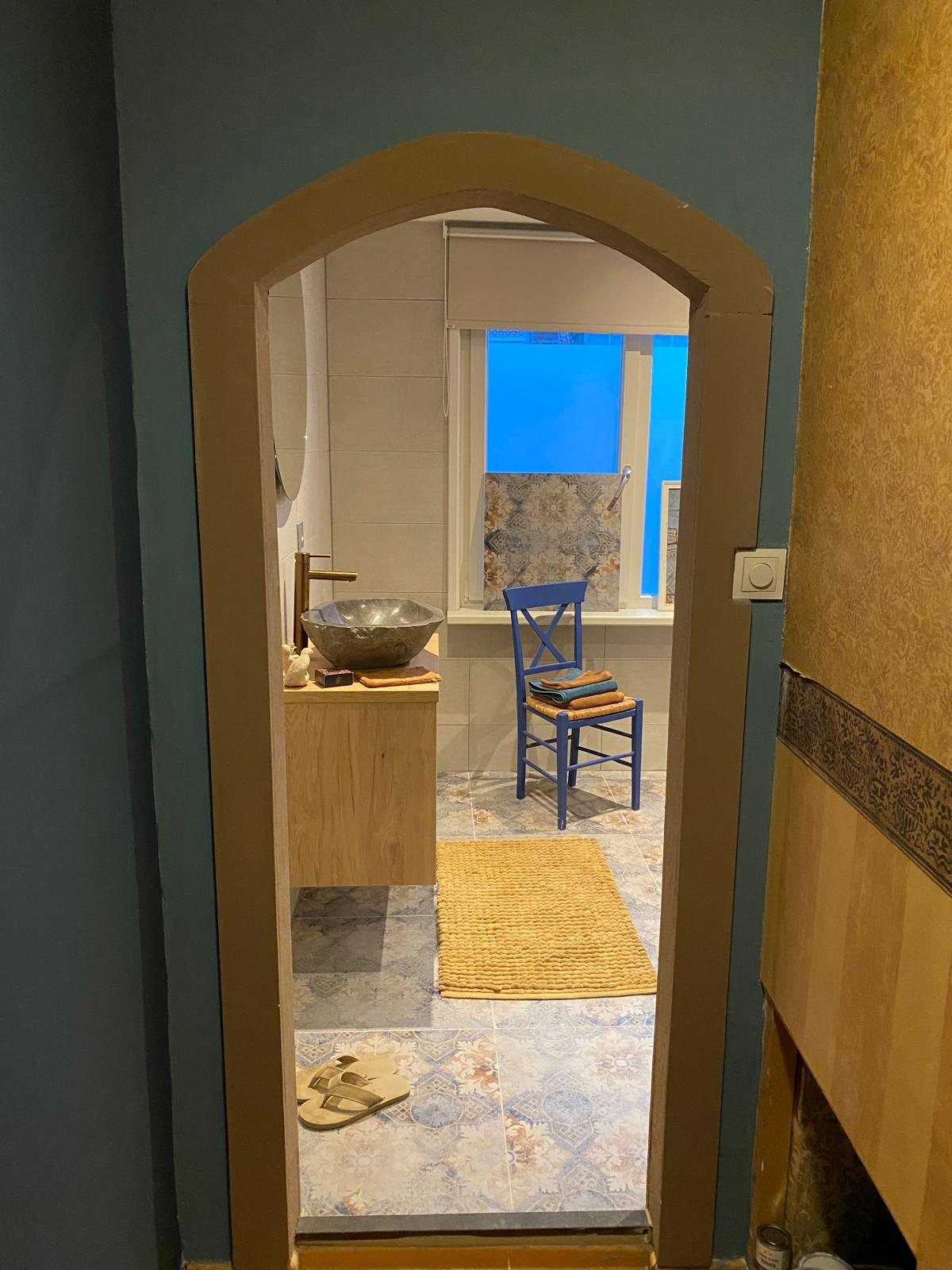 Badkamer met boog en natuurstenen waskom