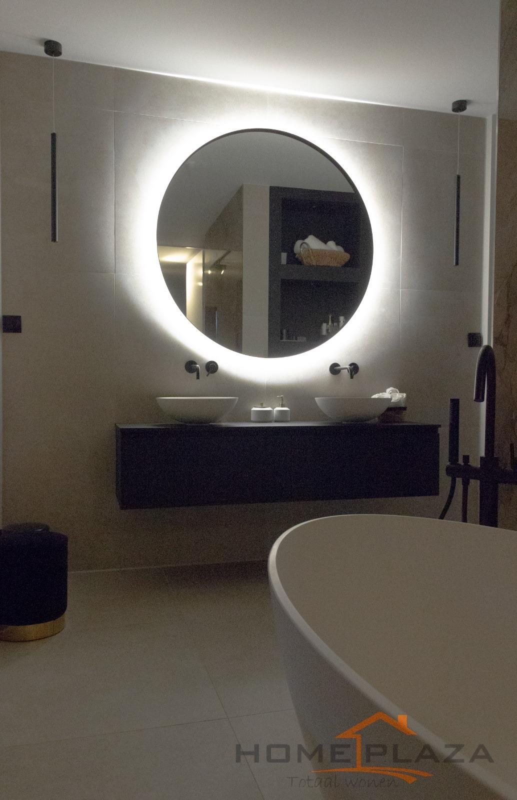 Badkamer met vrijstaand bad en ronde spiegel